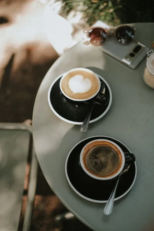 Two coffees on a caf&eacute; table, seen from above